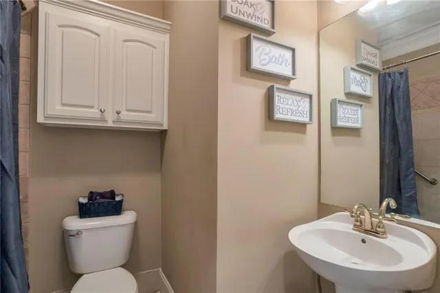 a bathroom with a toilet sink and mirror