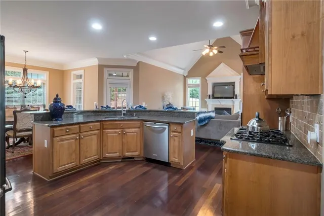 a kitchen with granite countertop a sink cabinets and wooden floor