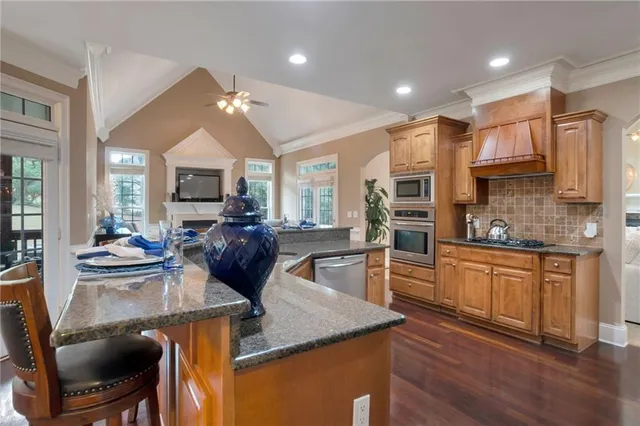 a kitchen with stainless steel appliances granite countertop a stove refrigerator and cabinets