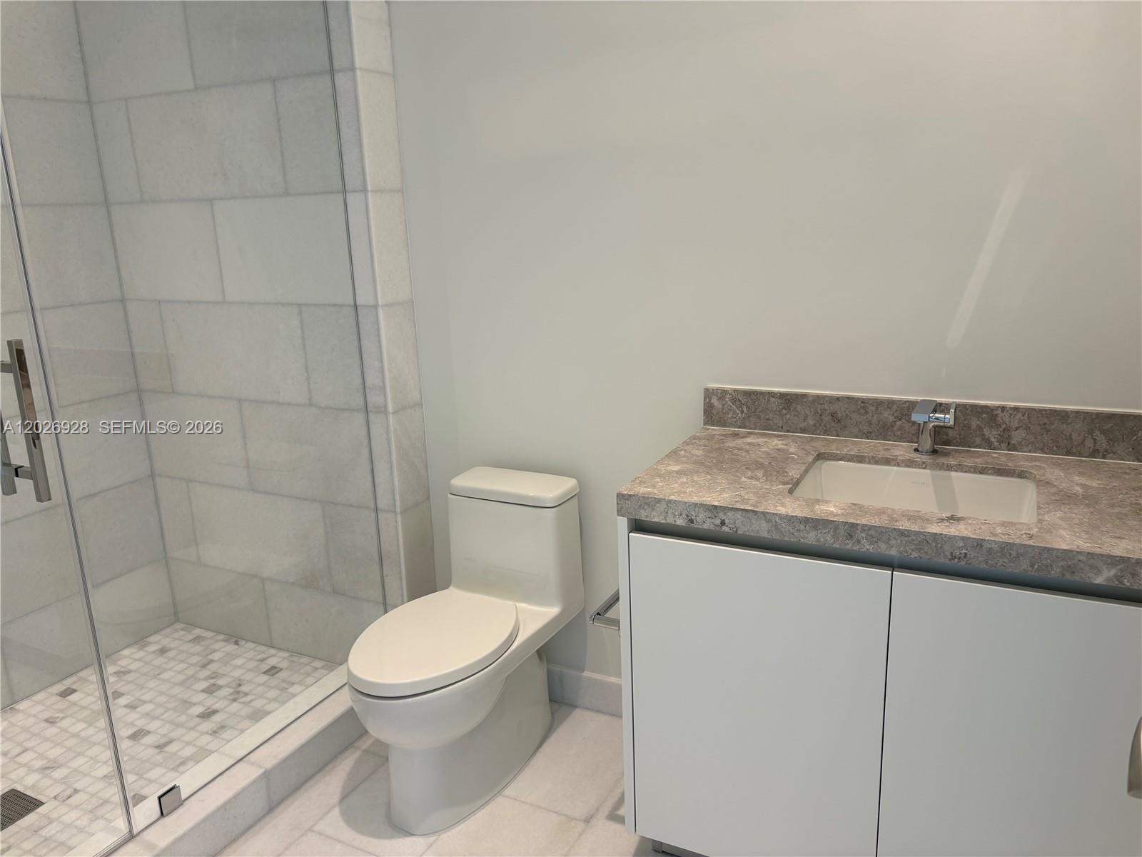 175 Southeast 25th Road, Unit 901 Miami, FL 33129 - Photo 16 of 18 a bathroom with a granite countertop sink a toilet and a shower