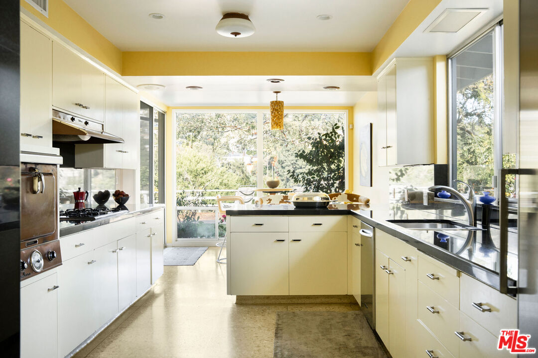 1023 Maybrook Drive Beverly Hills, CA 90210 - Photo 14 of 17 a kitchen with stainless steel appliances a sink a stove and white cabinets next to a window