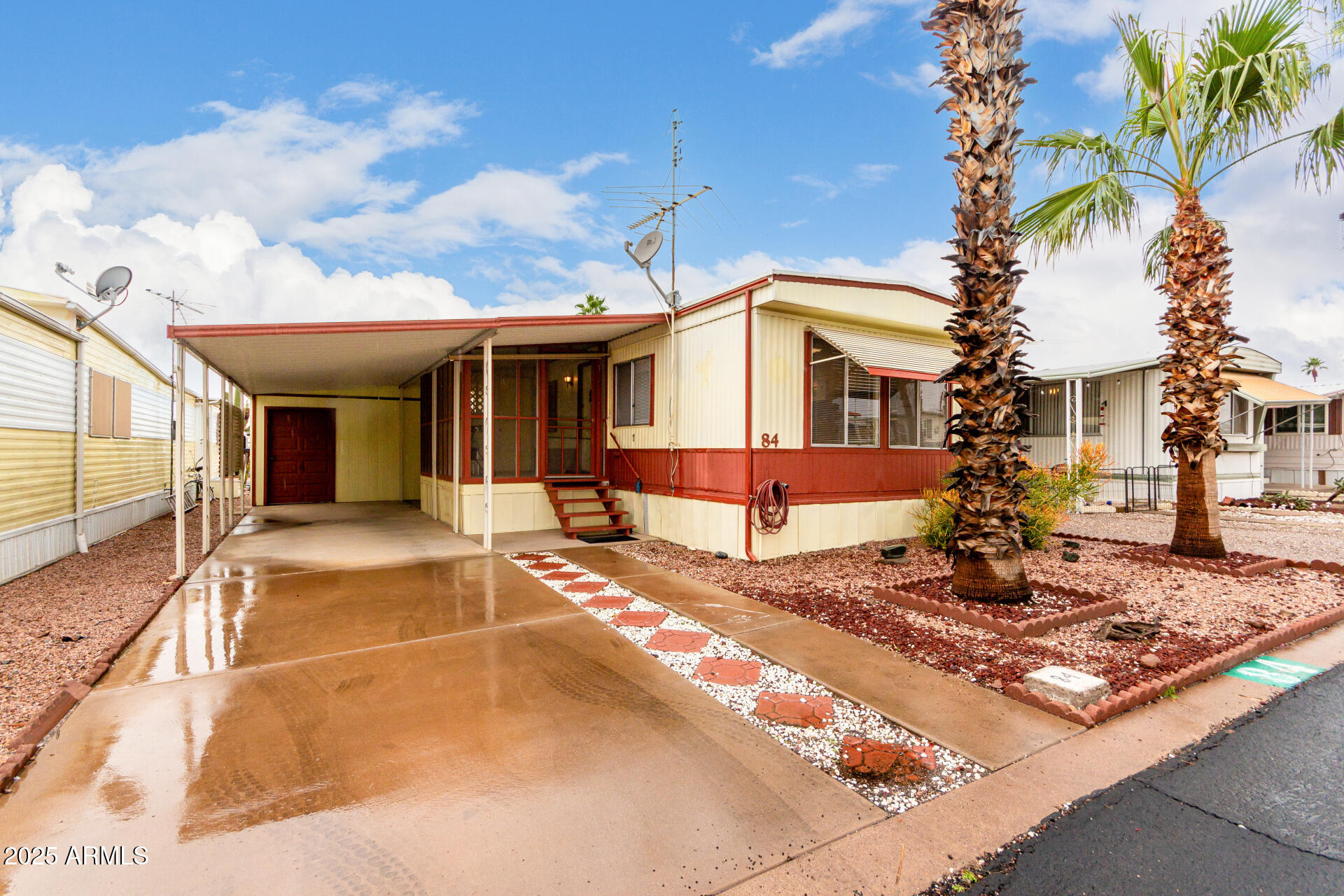 1050 East Broadway Avenue, Unit 84 Apache Junction, AZ 85119 - Photo 1 of 34 a view of a white house with a large tree