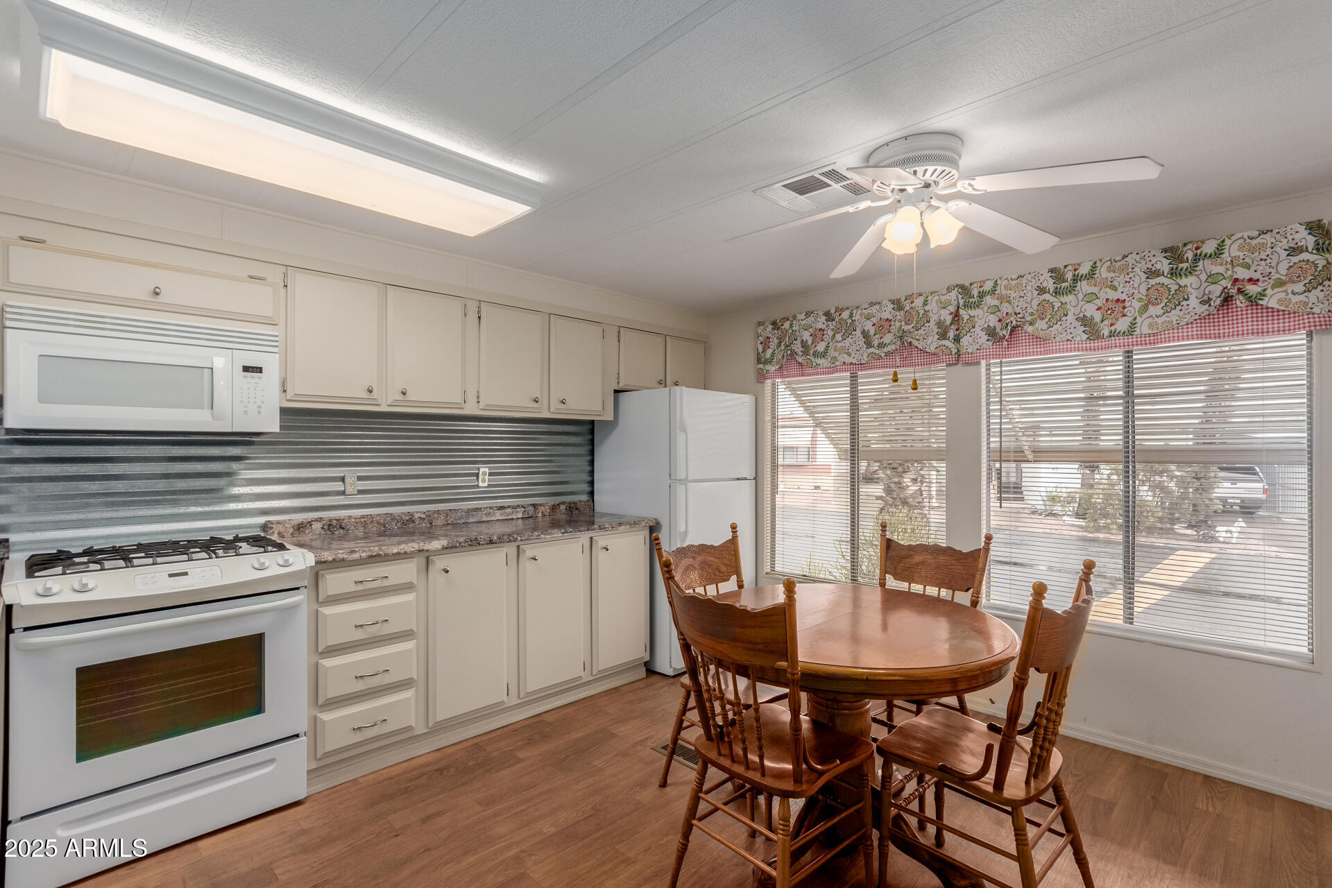 1050 East Broadway Avenue, Unit 84 Apache Junction, AZ 85119 - Photo 9 of 34 a kitchen with a dining table chairs stainless steel appliances and cabinets