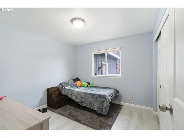 a bedroom with a bed and a painting on the wall