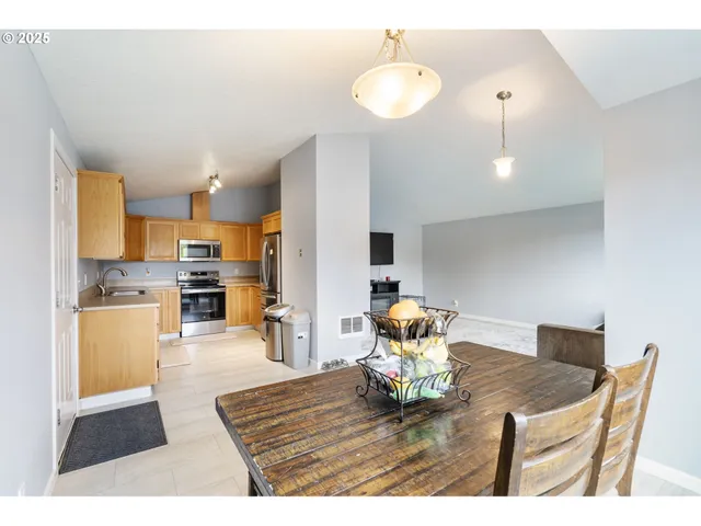 a living room with dining table a table and kitchen view