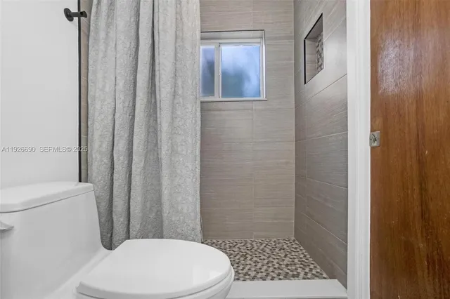 a bathroom with a toilet and a shower