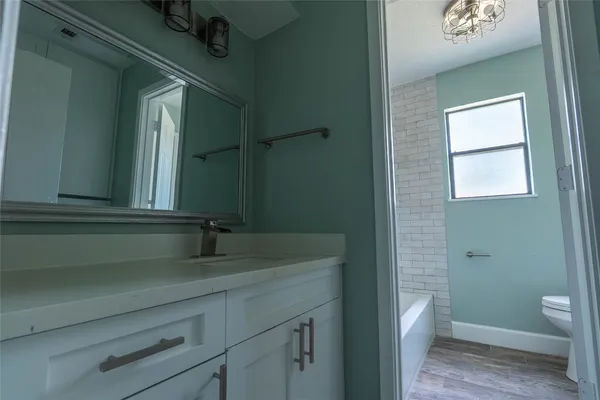 a bathroom with a granite countertop sink a toilet and a mirror