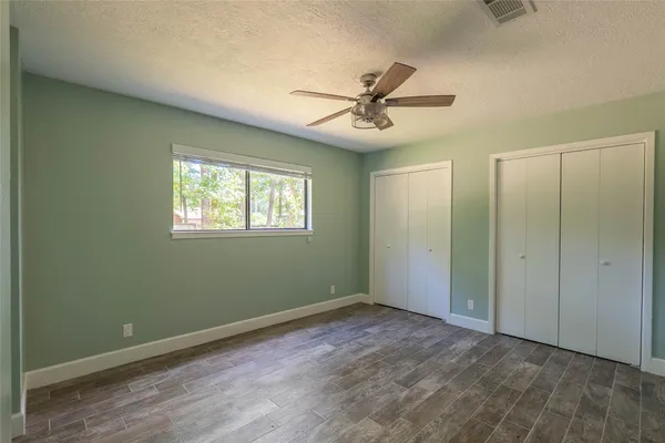 a view of a big room with wooden floor closet and windows
