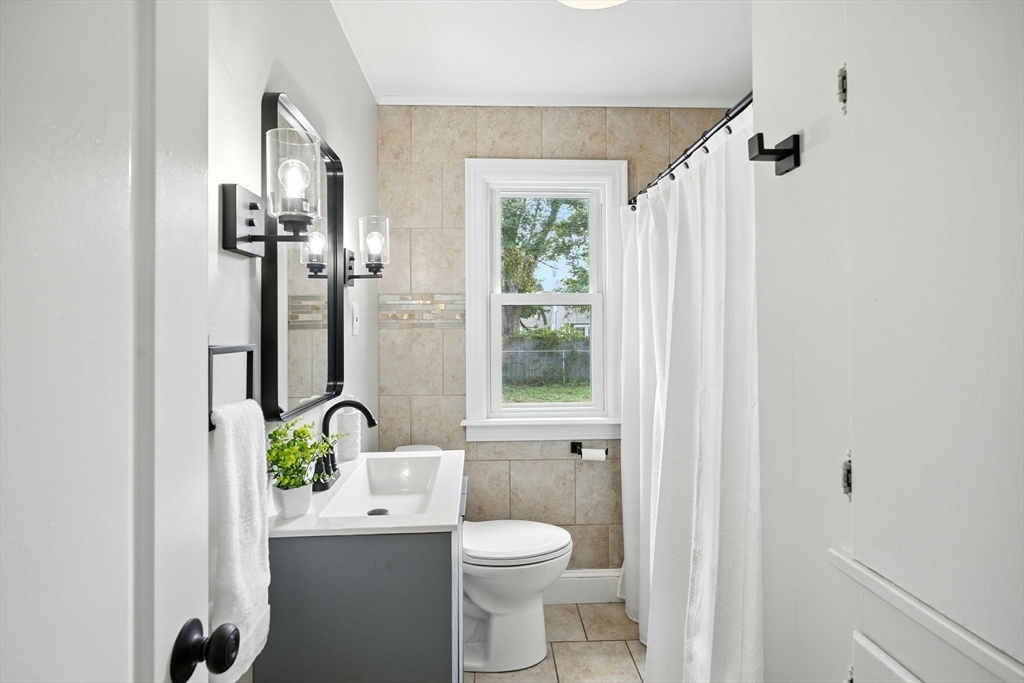 104 Grandview Street Springfield, MA 01118 - Photo 13 of 30 a bathroom with a toilet a sink and a window