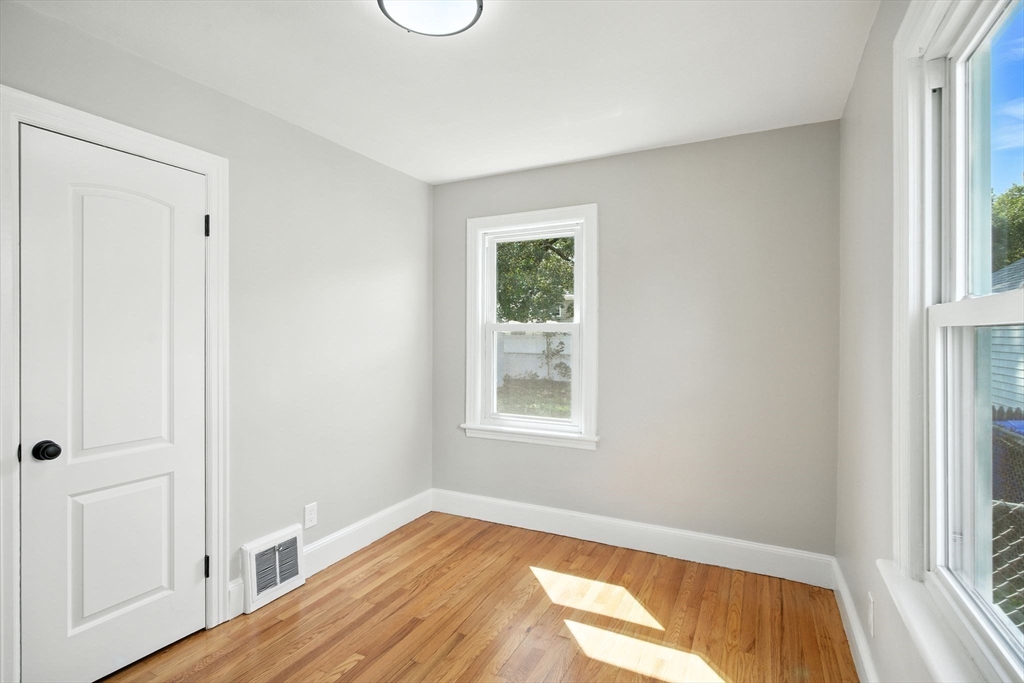 104 Grandview Street Springfield, MA 01118 - Photo 17 of 30 a view of an empty room with wooden floor and a window