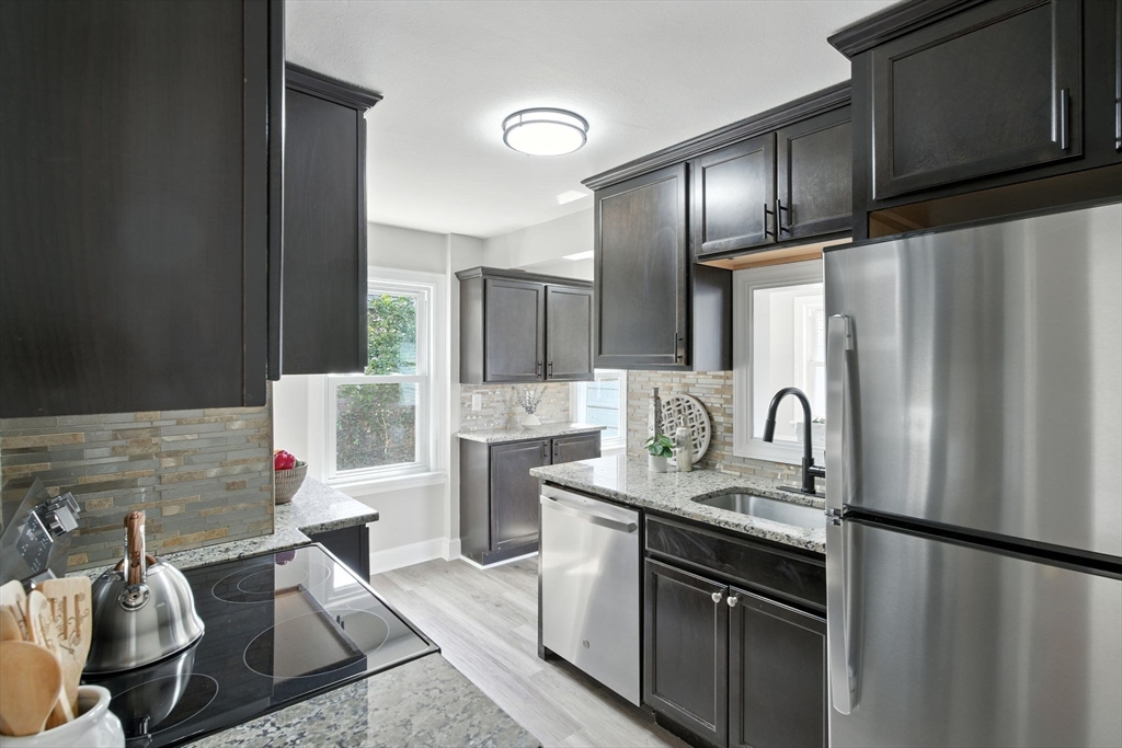 104 Grandview Street Springfield, MA 01118 - Photo 7 of 30 a kitchen with stainless steel appliances granite countertop a refrigerator sink and stove