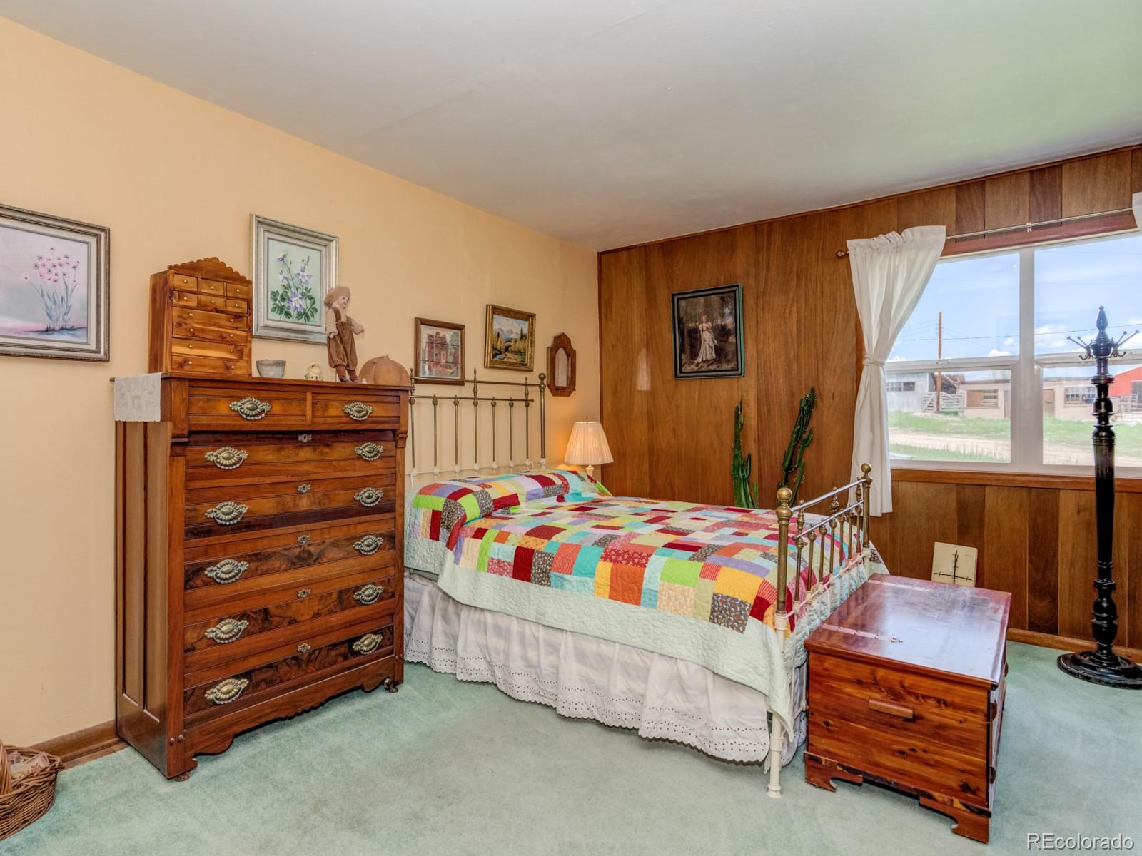 9695 Jones Road Franktown, CO 80116 - Photo 14 of 40 a bedroom with a bed and a dresser in it