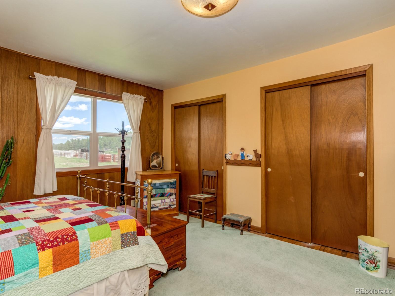 9695 Jones Road Franktown, CO 80116 - Photo 15 of 40 a bedroom with a bed and large windows