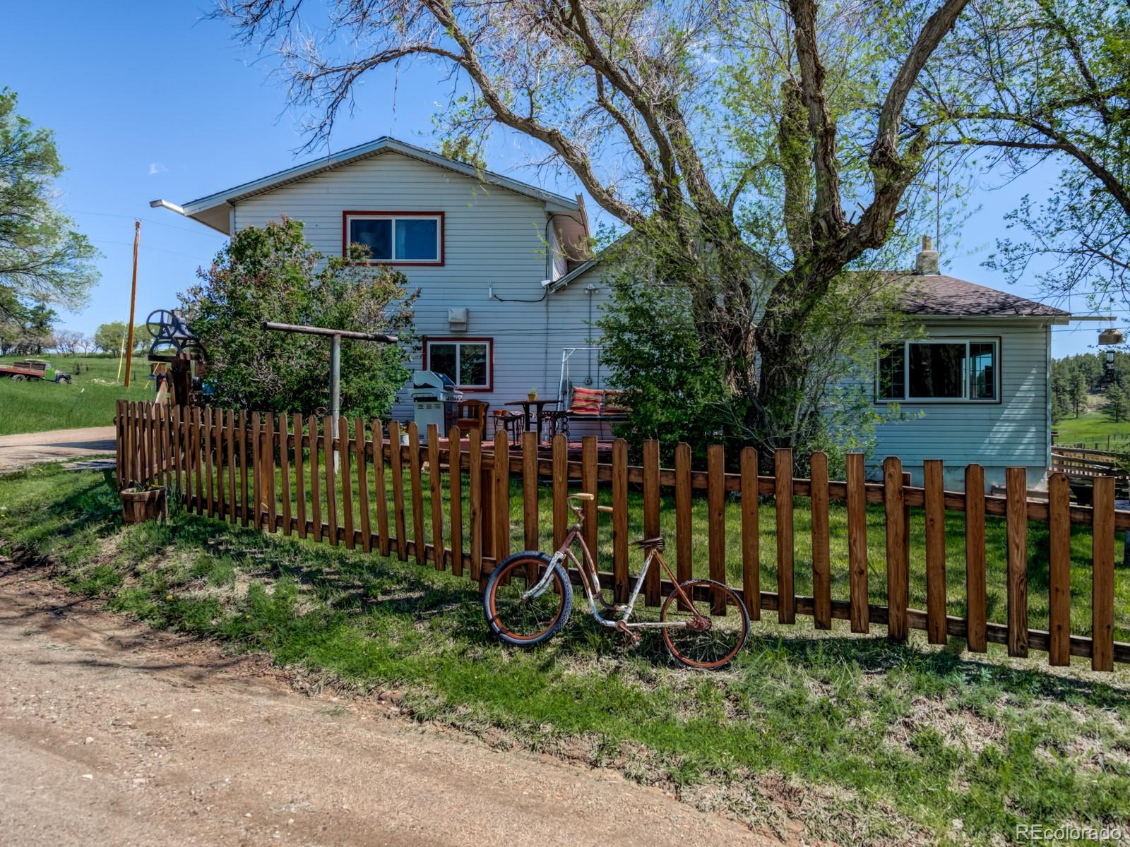 9695 Jones Road Franktown, CO 80116 - Photo 3 of 40 a view of a house with a yard and plants