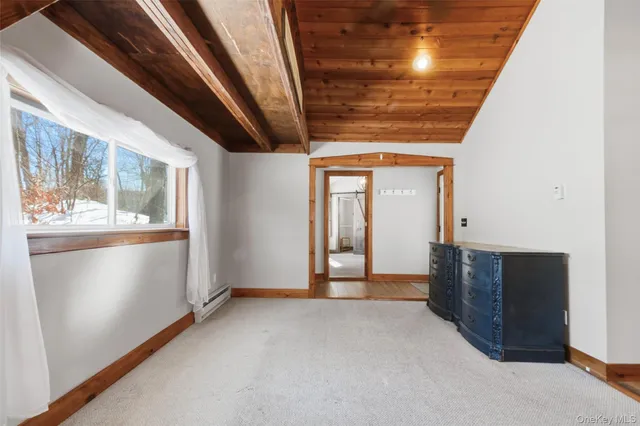 a view of an empty room with wooden floor and windows