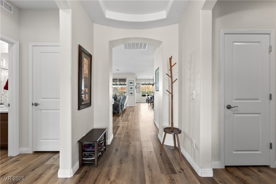 1221 Tortoise Ridge Mesquite, NV 89034 - Photo 12 of 56 Hallway with arched walkways, dark wood-style flooring, and a raised ceiling
