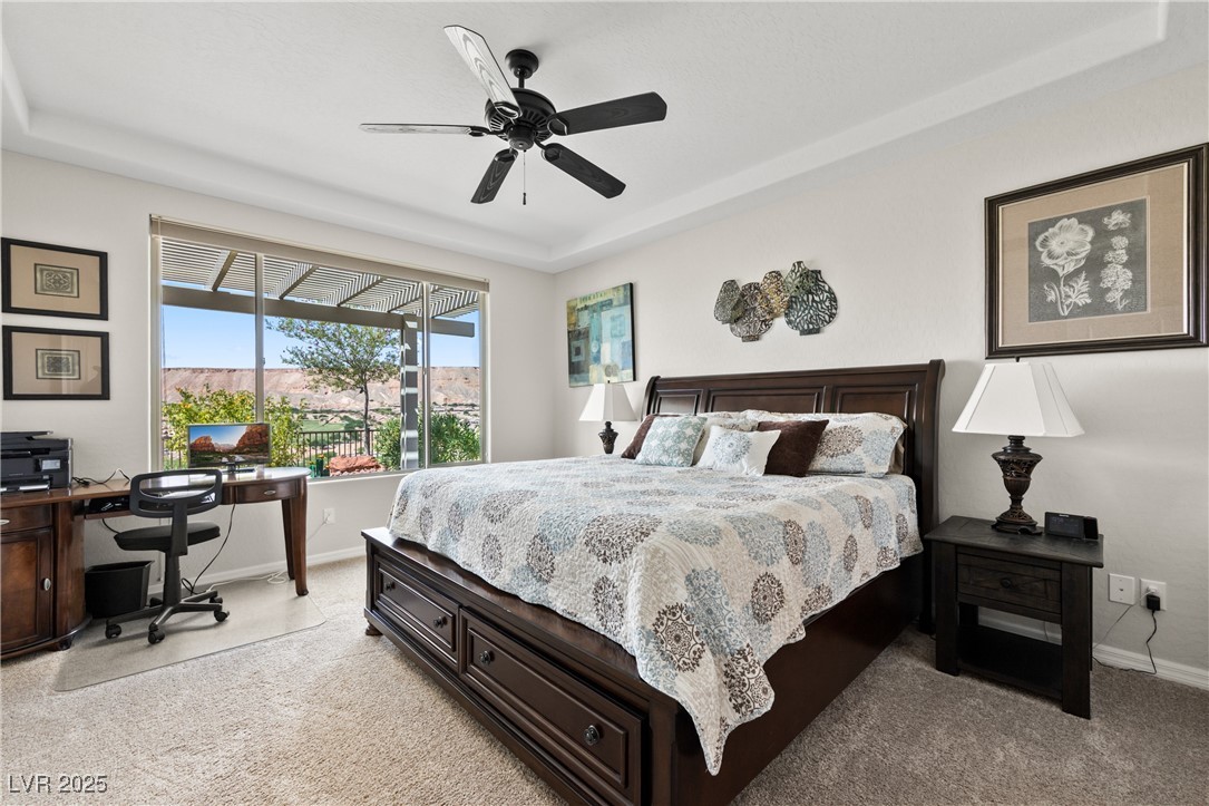 1221 Tortoise Ridge Mesquite, NV 89034 - Photo 26 of 56 Bedroom featuring a raised ceiling, an office area, ceiling fan, and light carpet