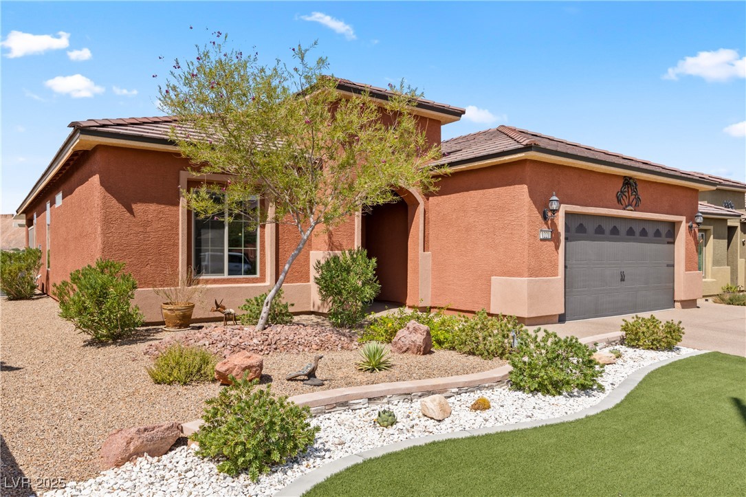 1221 Tortoise Ridge Mesquite, NV 89034 - Photo 3 of 56 View of front facade featuring a tiled roof, a garage, stucco siding, and concrete driveway