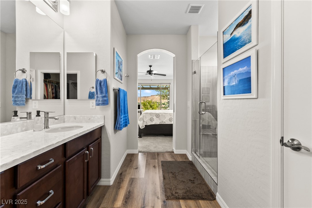 1221 Tortoise Ridge Mesquite, NV 89034 - Photo 31 of 56 Full bathroom with ensuite bath, a shower stall, vanity, a ceiling fan, and dark wood-type flooring
