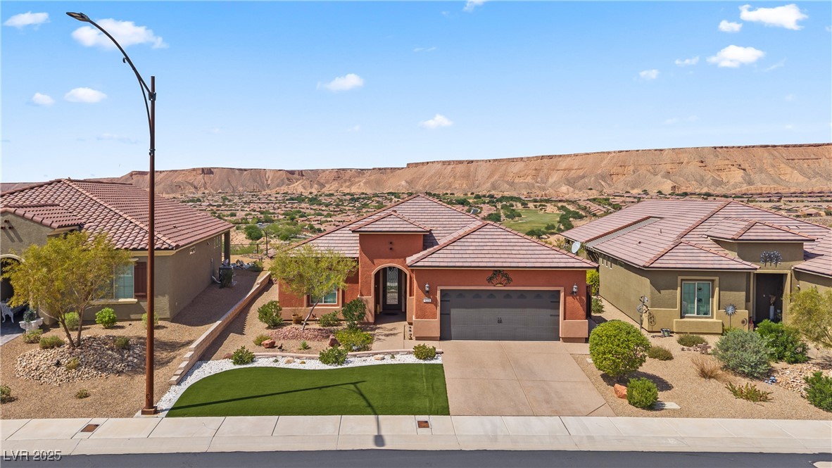 1221 Tortoise Ridge Mesquite, NV 89034 - Photo 53 of 56 Mediterranean / spanish house featuring driveway, an attached garage, stucco siding, and a tile roof