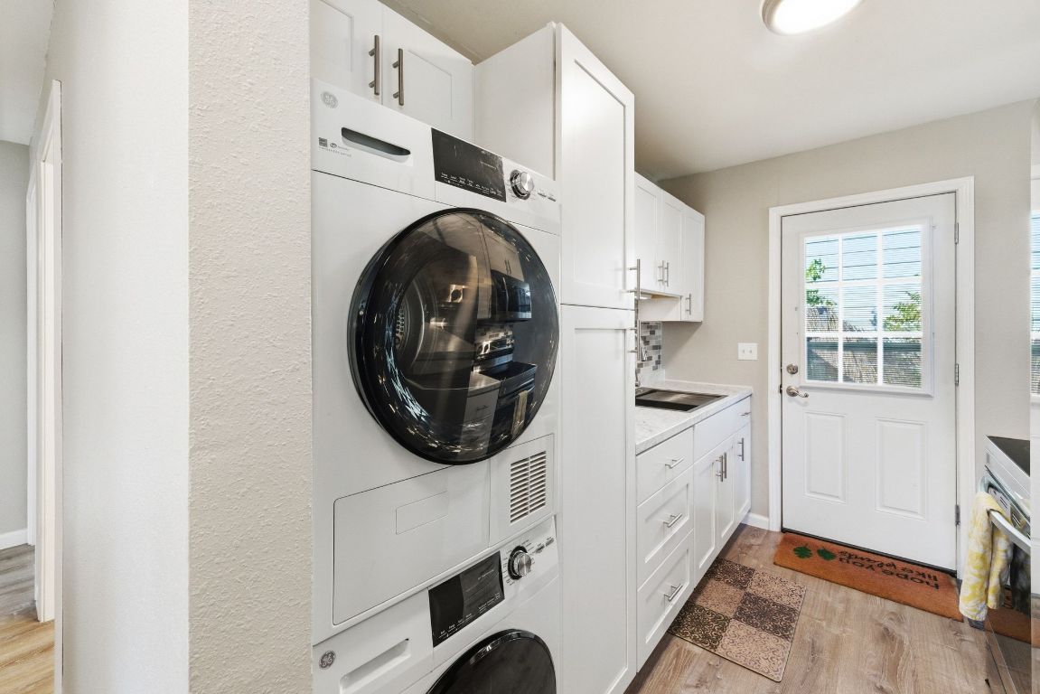 4615 Munson Street Austin, TX 78721 - Photo 22 of 27 Laundry room featuring stacked washer and clothes dryer and light wood finished floors