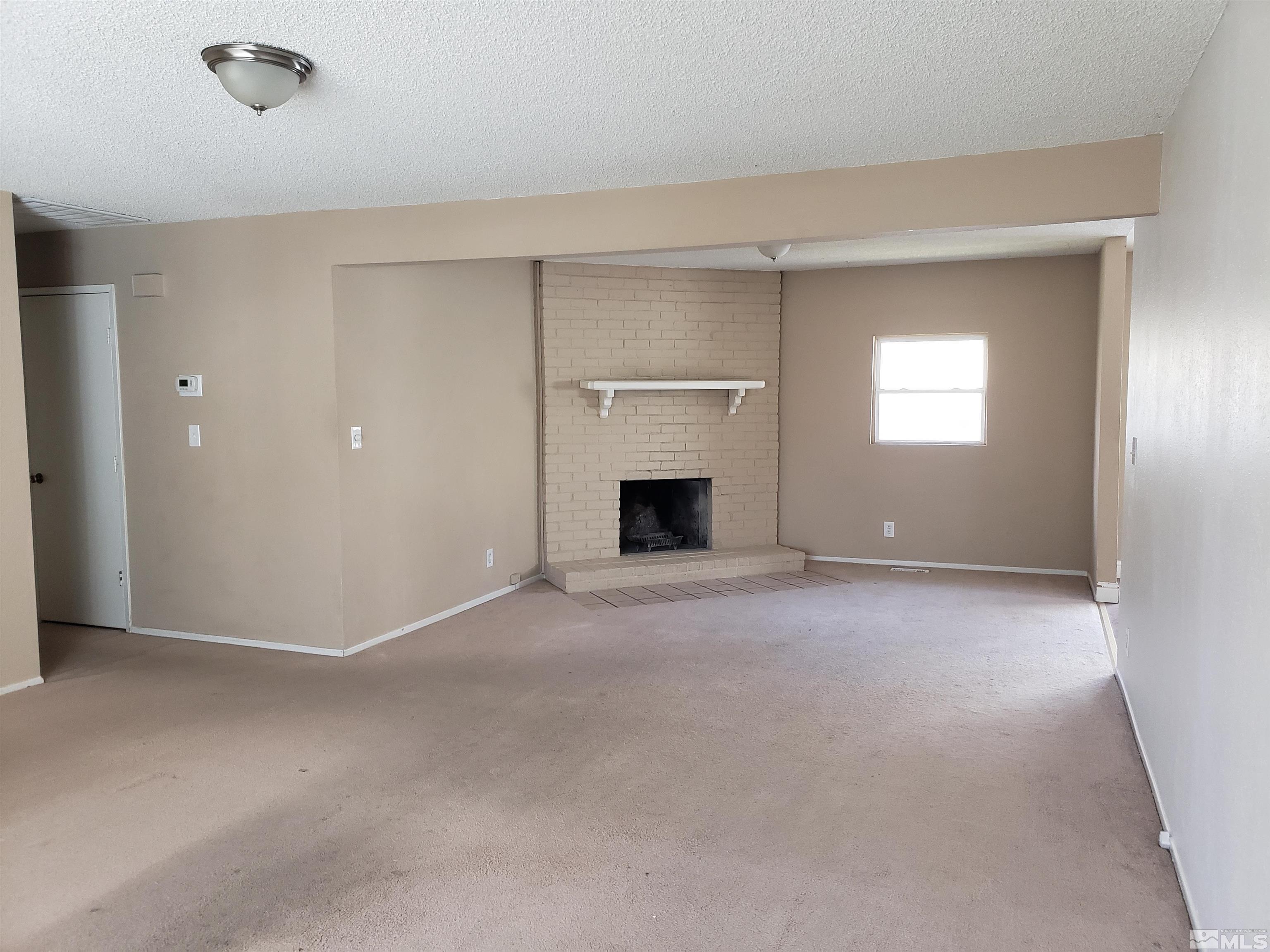 1545 Peavine Road Reno, NV 89503 - Photo 3 of 11 a view of empty room with a fireplace