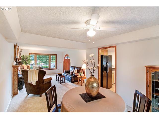 15851 Southeast Tong Road Damascus, OR 97089 - Photo 5 of 16 a living room with furniture a flat screen tv and a large window