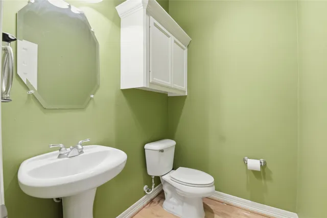 a bathroom with a toilet sink and mirror