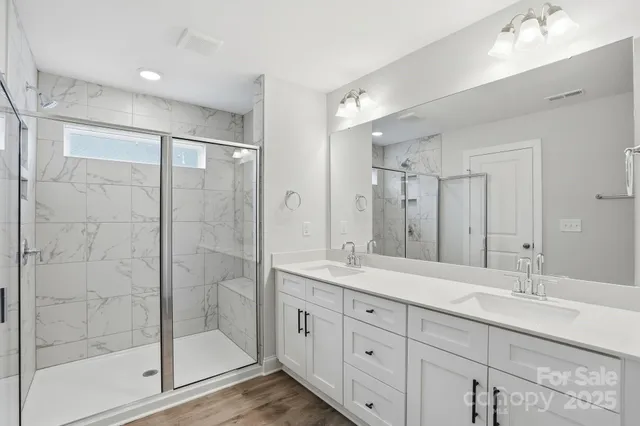a bathroom with a shower sink and mirror