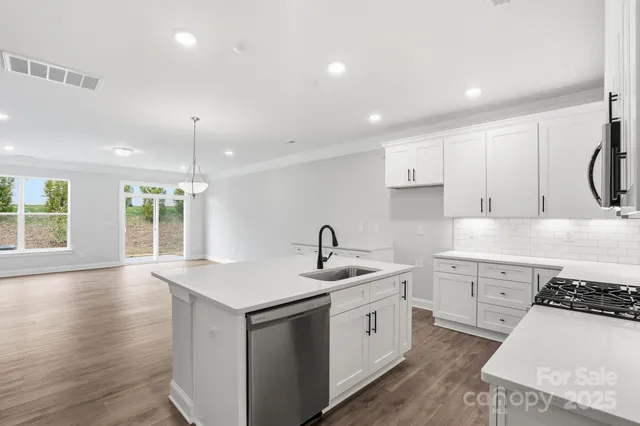 a kitchen with a white stove top oven sink and cabinets