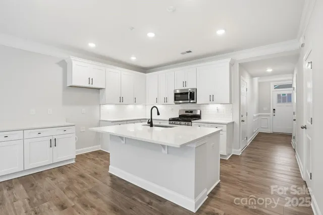 a large white kitchen with cabinets