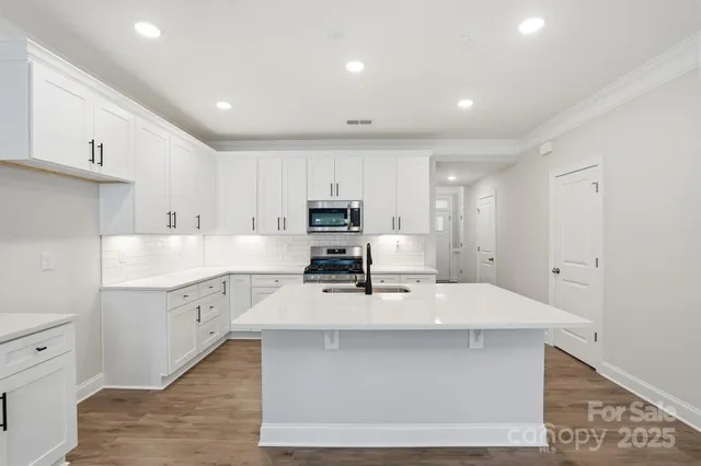 a large kitchen with kitchen island a sink stainless steel appliances and cabinets
