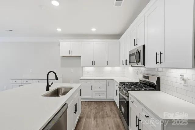 a kitchen with a sink stove top oven and cabinets