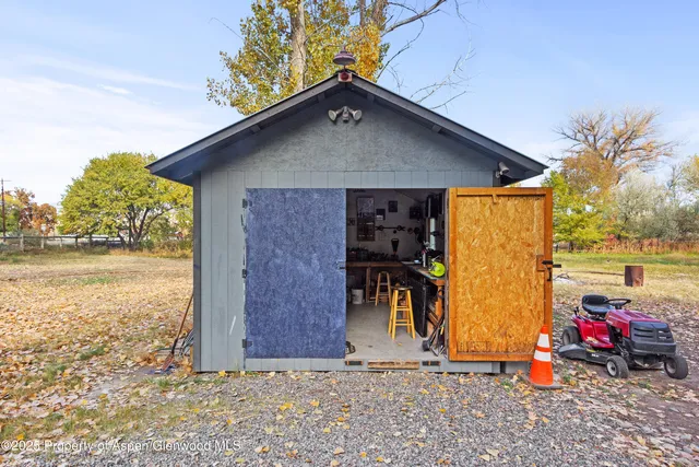 a view of a chair and table in backyard of the house