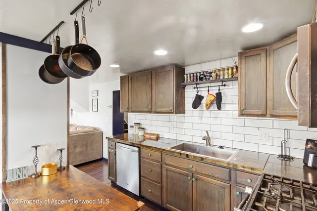 a kitchen with stainless steel appliances granite countertop a sink a stove and cabinets