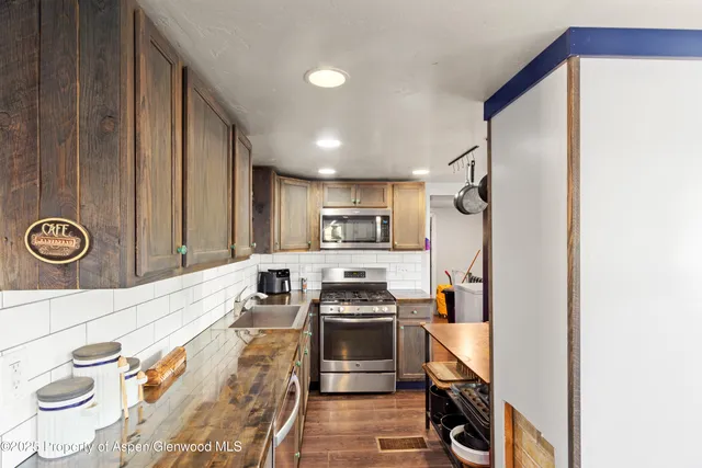 a kitchen with stainless steel appliances granite countertop a refrigerator and a stove