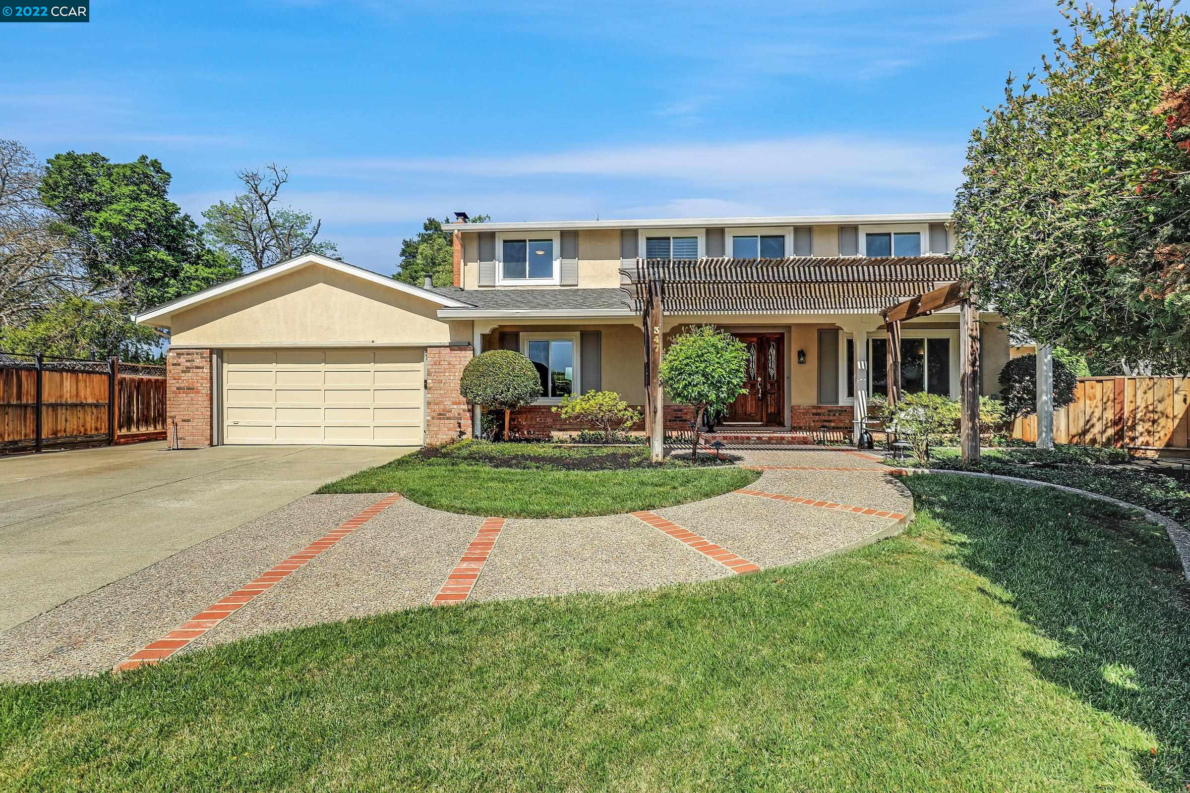 a front view of a house with a yard and green space
