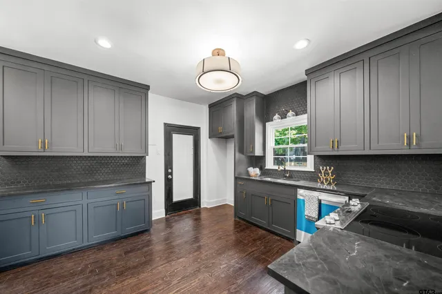 a kitchen with stainless steel appliances granite countertop a stove a sink a refrigerator and cabinets