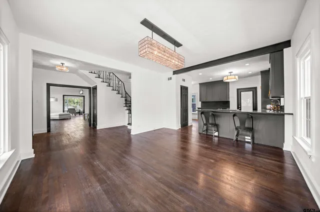 a view of a livingroom with furniture wooden floor and a kitchen