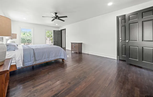 a spacious bedroom with a bed and a ceiling fan
