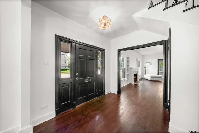 a view of a hallway with wooden floor windows and a kitchen
