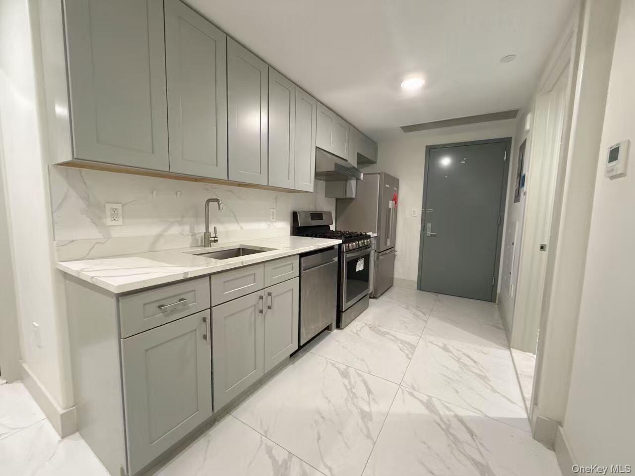 41-62 Bowne Street, Unit 3E Queens, NY 11355 - Photo 4 of 9 a kitchen with a sink cabinets and stainless steel appliances