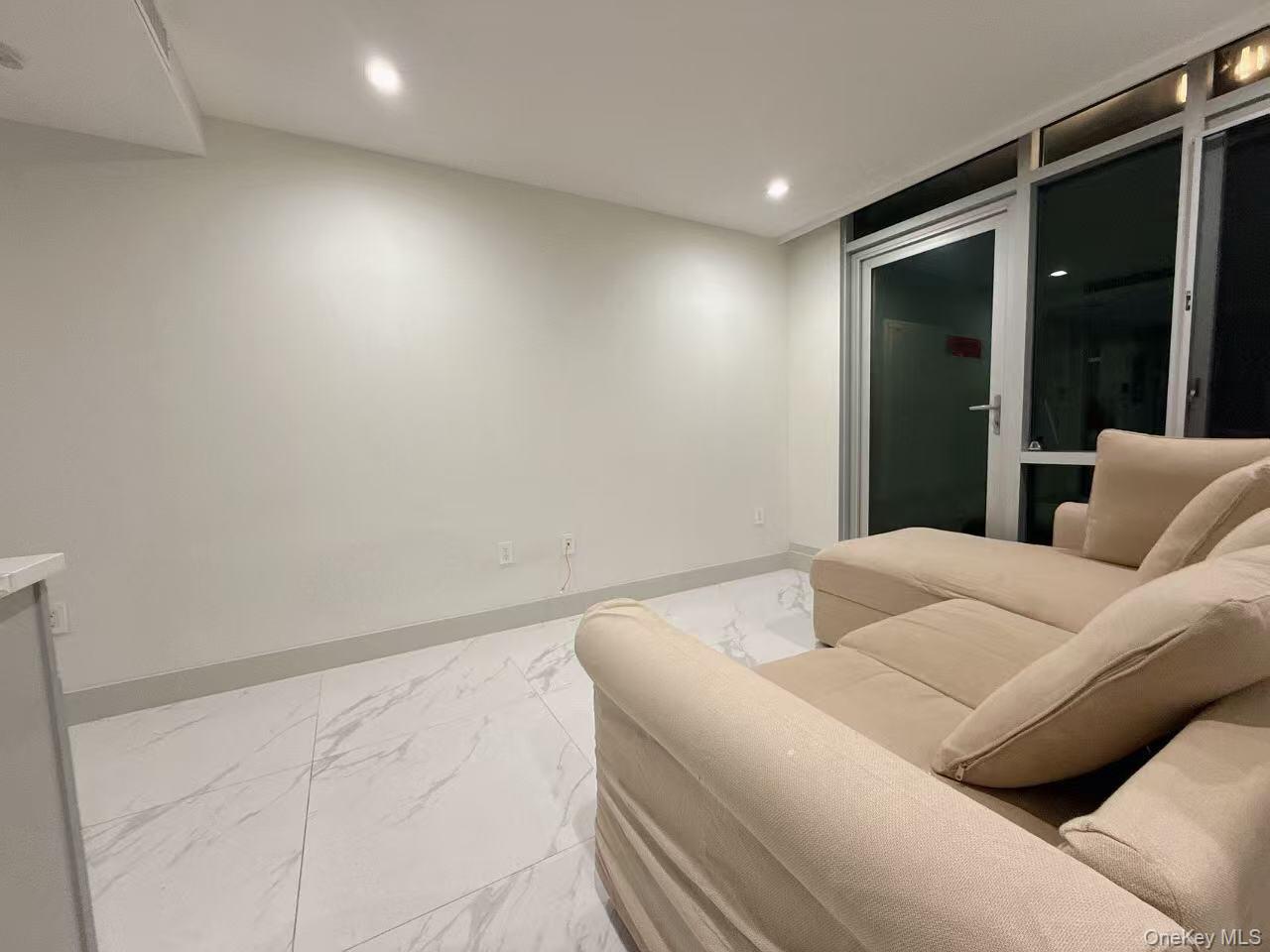 41-62 Bowne Street, Unit 3E Queens, NY 11355 - Photo 5 of 9 a bedroom with a bed and a large window