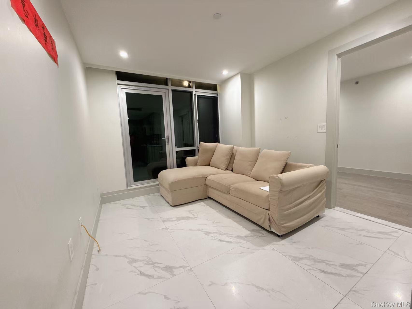 41-62 Bowne Street, Unit 3E Queens, NY 11355 - Photo 7 of 9 a living room with furniture and a ceiling fan