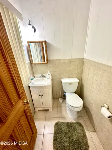 a bathroom with a toilet a sink and a mirror