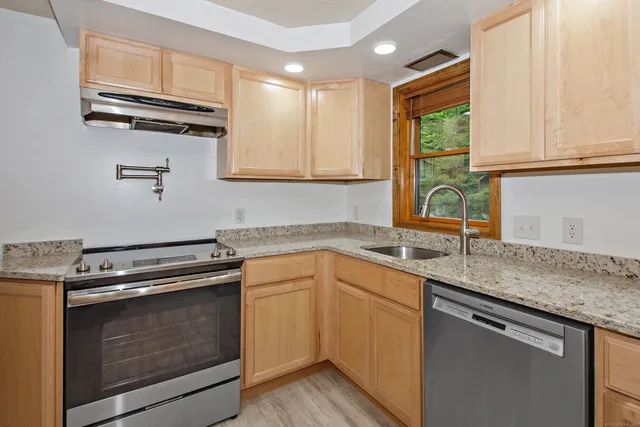 a kitchen with kitchen island granite countertop wooden floors and stainless steel appliances