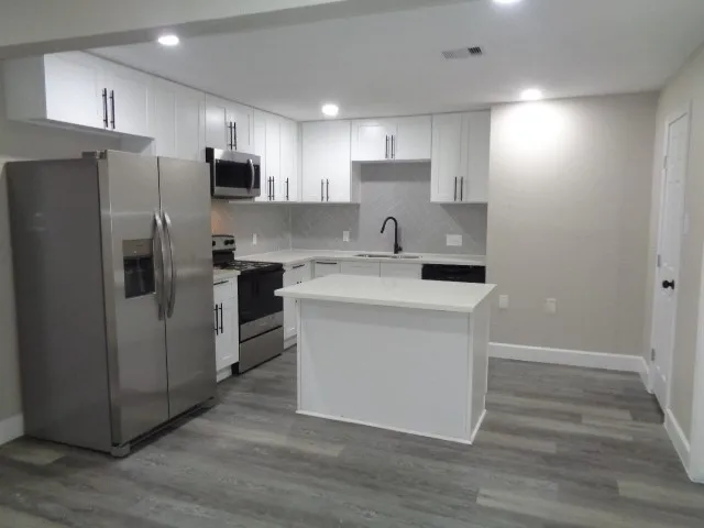 a kitchen with stainless steel appliances a refrigerator sink and microwave