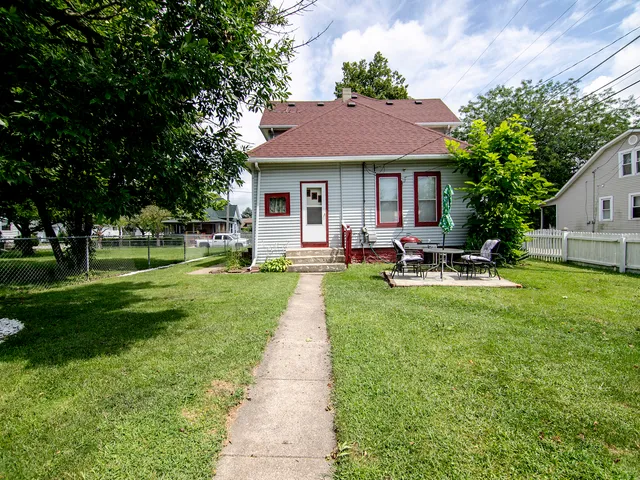 a front view of house with yard and outdoor seating