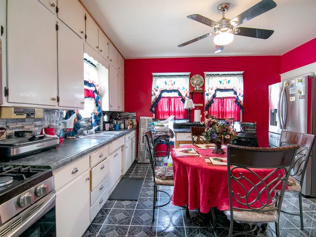 a kitchen with stainless steel appliances kitchen island granite countertop a stove a sink dishwasher and a dining table with chairs