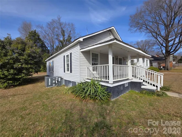 a view of a house with a yard and fence